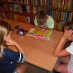 uczestnicy bibliotecznych zajęć słuchają dzisiejszej opowieści czytanej przez jednego z chłopców