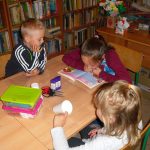 uczestnicy zajęć z uwagą słuchają opowieści czytanej przez jedną z dziewczynek