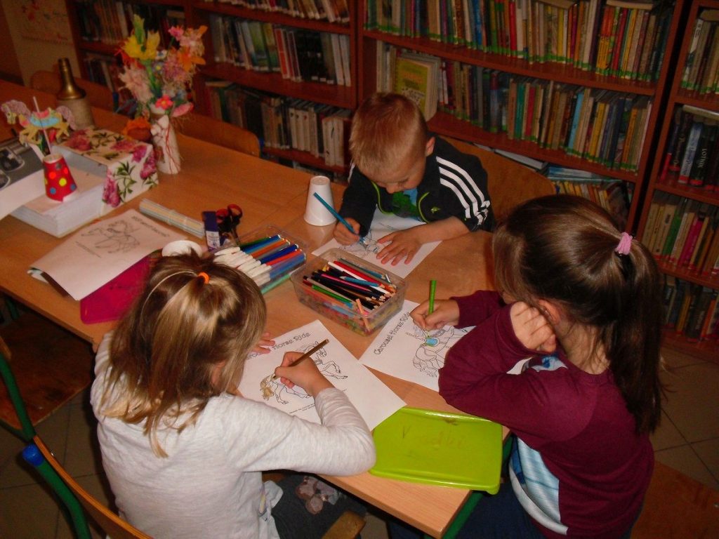 dzieci przystępują do kolorowania karuzelowych koników