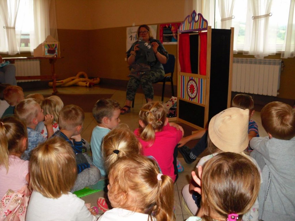 dzieci z uwagą słuchają opowieści pani Justyny Bednarek o skarpetkowych bohaterkach napisanej przez nią serii książek dla dzieci