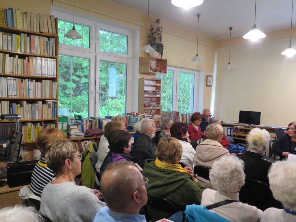 Goście zebrani w czytelni Biblioteki Głównej podziwiają historyczne zdjęcia i słuchają interesujących komentarzy pani Danuty