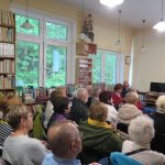 Goście zebrani w czytelni Biblioteki Głównej podziwiają historyczne zdjęcia i słuchają interesujących komentarzy pani Danuty