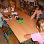 dzieci słuchają dzisiejszej opowieści czytanej przez jedną z dziewczynek