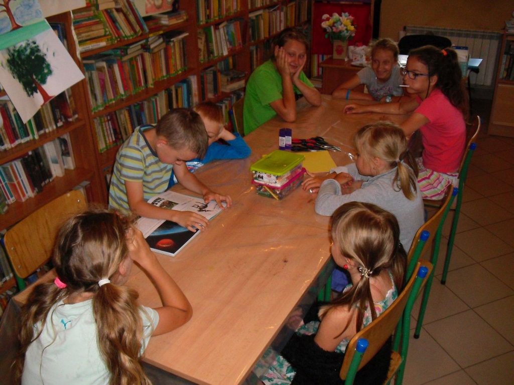 chłopiec czyta opowiadanie uczestnikom dzisiejszych zajęć