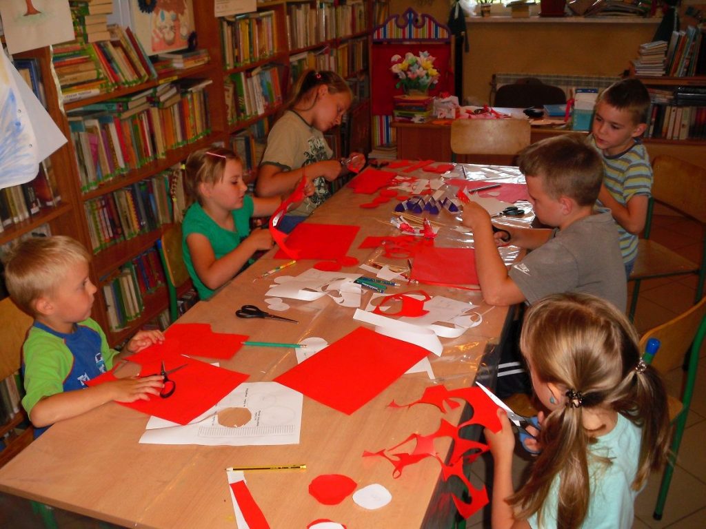 dzieci wycinają elementy swoich róż z kolorowego papieru