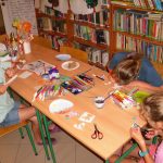 dzieci w skupieniu malują papierowe talerzyki, które będą tłem dla naszych kwitnących roślinek