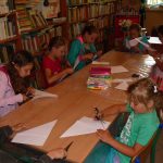 dzieci w skupieniu wycinają i składają kartki do dzisiejszej pracy