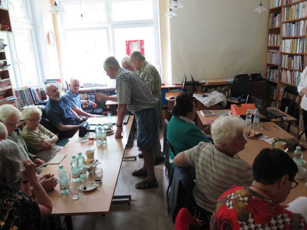 Pan Leszek Walczyk opowiada zebranym o zbudowanych przez siebie makietach przedwojennych krynickich domów