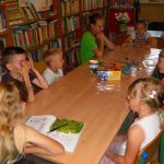 dzieci z uwagą słuchają dzisiejszej porcji ciekawostek czytanej przez jedną z dziewczynek