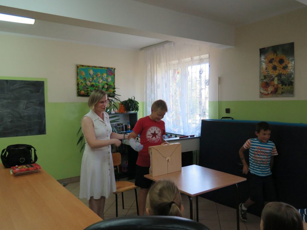 Zgromadzone na świetlicy dzieci siedzą na krzesłach i ochoczo zgłaszają się chcąc odpowiedzieć na pytania Pani Bibliotekarki