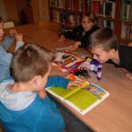 Dzieci z zainteresowaniem słuchają dalszej części opowieści czytanej przez jednego z chłopców