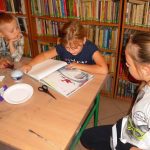 dzieci z uwagą słuchają bajki czytanej przez jedną z dziewczynek