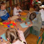 Grupa dzieci podczas zajęć w bibliotece, po odczytaniu dzisiejszej opowieści, tworzy własne kolorowe drzewa