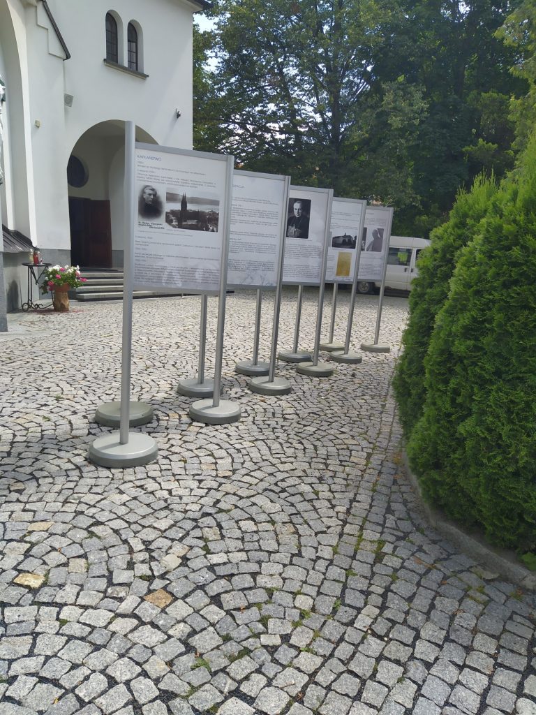 Plansz z wystawą przed Parafią Zdrojową .