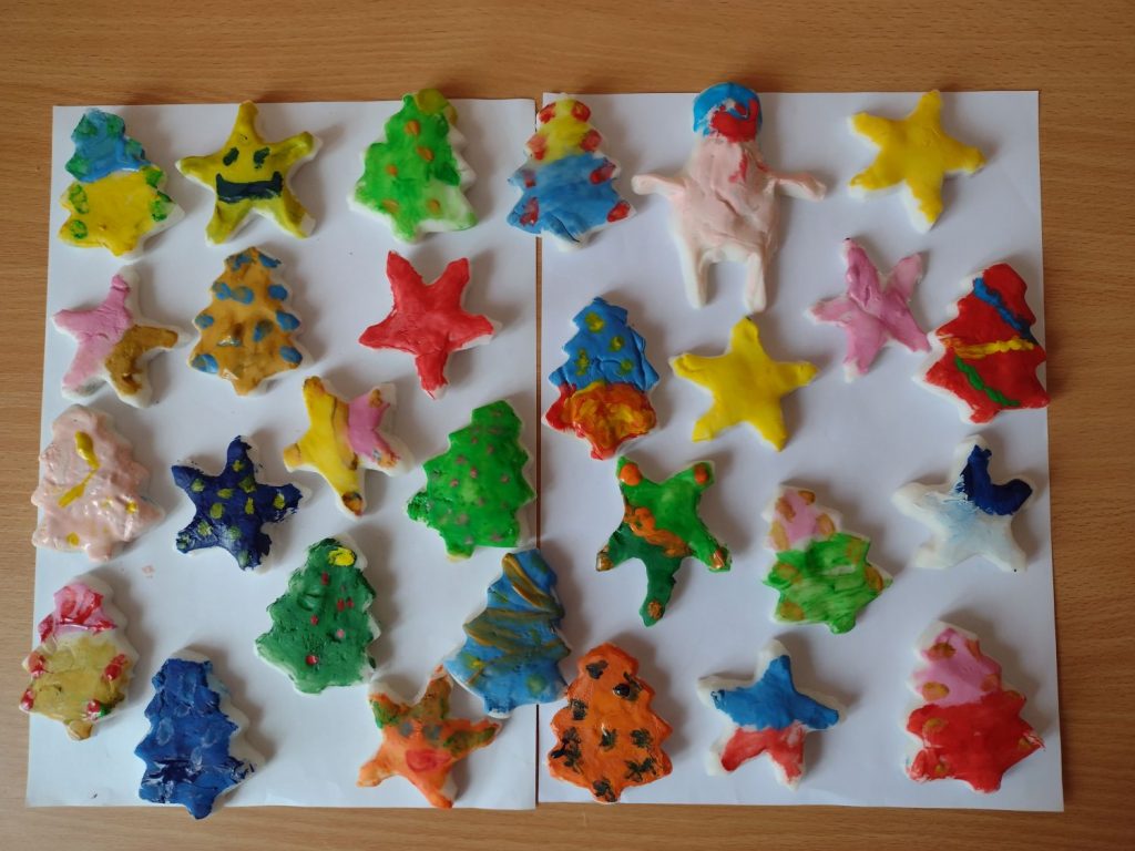 Na zdjęciu figurki wykonane z masy porcelanowej wielokolorowe gwiazdki, mikołaj,choinka, aniołek.
