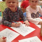 Dwie dziewczynki siedzą przy stoke i wykonuja prace plastyczne