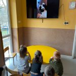 W przedszkolnej sali siedzą dzieci i z zaciekawieniem wpatrują się w duży ekran telewizora na którym widać czytającego bajkę Pana Borsuka