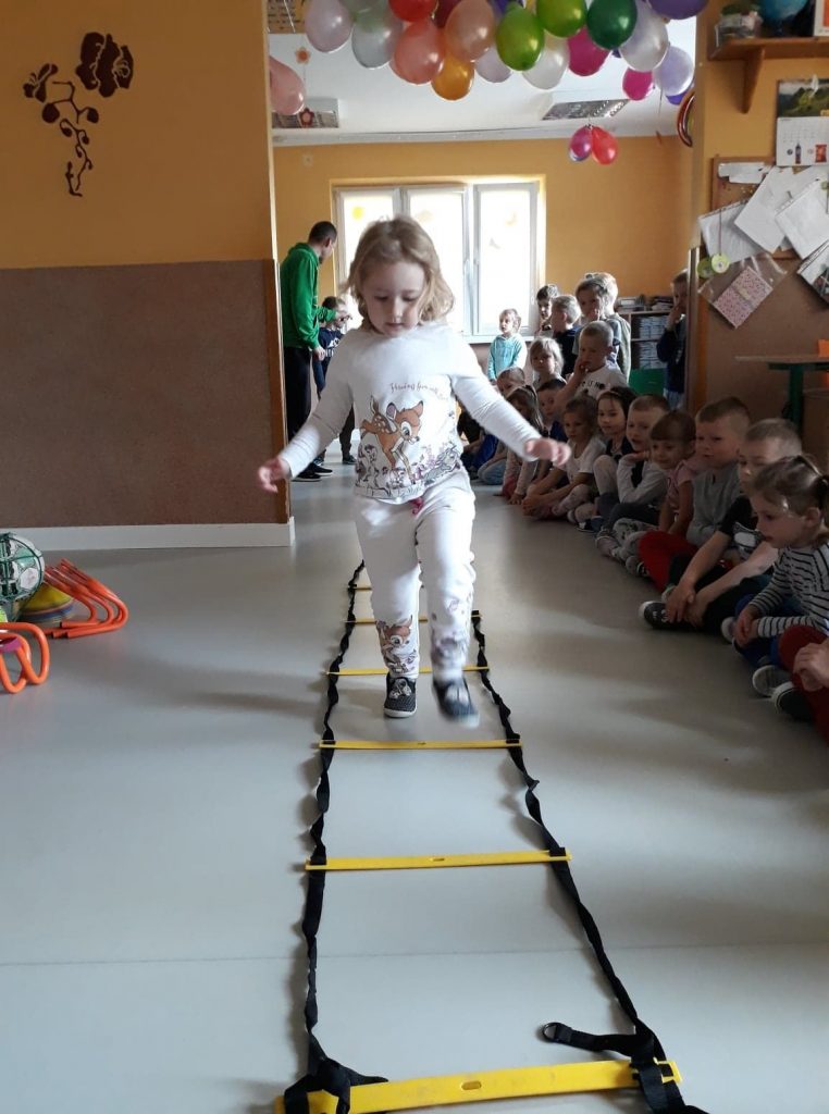 Na środku sali mała, ale zwinna dziewczynka bez problemów wykonuje ćwiczenia na rozłożonej drabince koordynacyjnej, reszta grupy siedzi pod ścianą i czeka z niecierpliwością na swoją kolej.