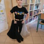 Młoda uczestniczka wakacyjnych Eko- warsztatów z uśmiechem na ustach prezentuje wykonane własnoręcznie przed chwilą dwie piękne torby na zakupy.