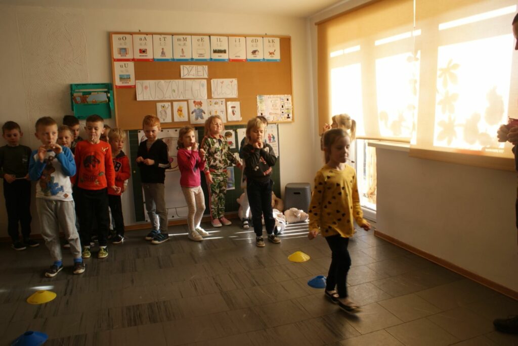 W sali przedszkolnej właśnie rozgrywane są wyścigi. Dzieci trzymają w buziach łyżeczki w których umieszczone są słodkie misie żelki i mają za zadanie pokonać ułożony na podłodze slalom.