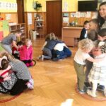 Na zdjęciu widać bawiące się dzieci wraz z przebraną w geparda bibliotekarkę
