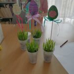 Na zdjęciu widoczne są pisankowe pikery umieszczone w kubeczkach z owsem.
