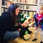 na zdjęciu widać pluszową żąbe na niej kolorowe motylki oraz chłopca i bibliotekarkę