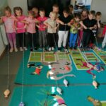 W grupie „starszaków” właśnie trwają zawody wędkarskie. Uczestnicy na wyścigi nawijają na patyczki linki, do których na końcu przyczepione są małe, kolorowe rybki.