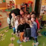 Przedszkolaki zbiły się w ciasną grupkę kładąc swoje ręce na rękę pana bibliotekarza. Za chwilę nastąpi pożegnanie gromkim okrzykiem: „Hej wiewiórki!”.