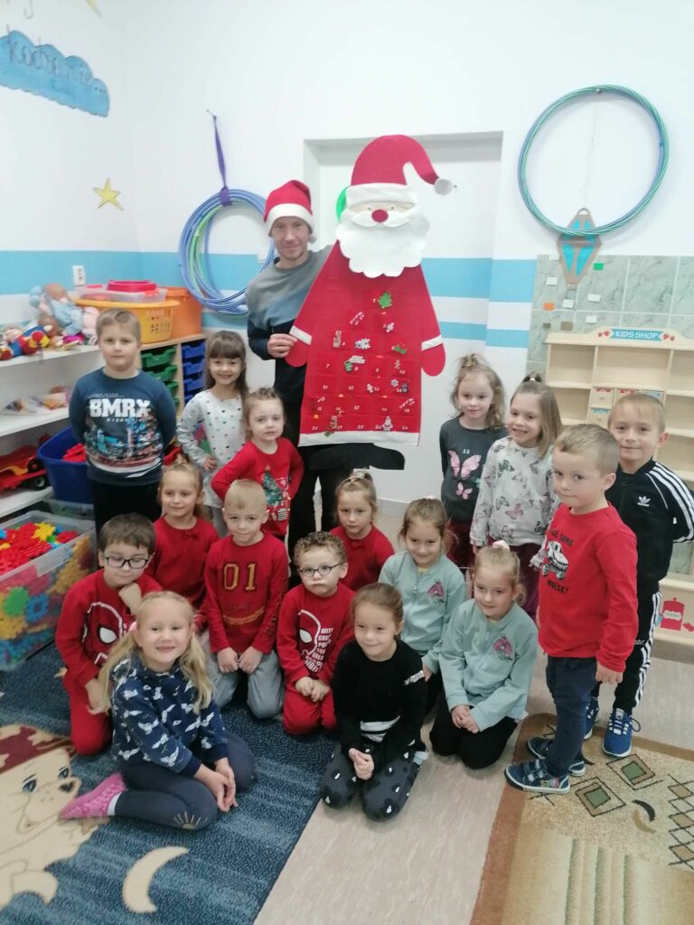 Na końcu zajęć uśmiechnięte dzieci i pan bibliotekarz ustawili się razem przy figurce wesołego świętego Mikołaja do pamiątkowego zdjęcia.