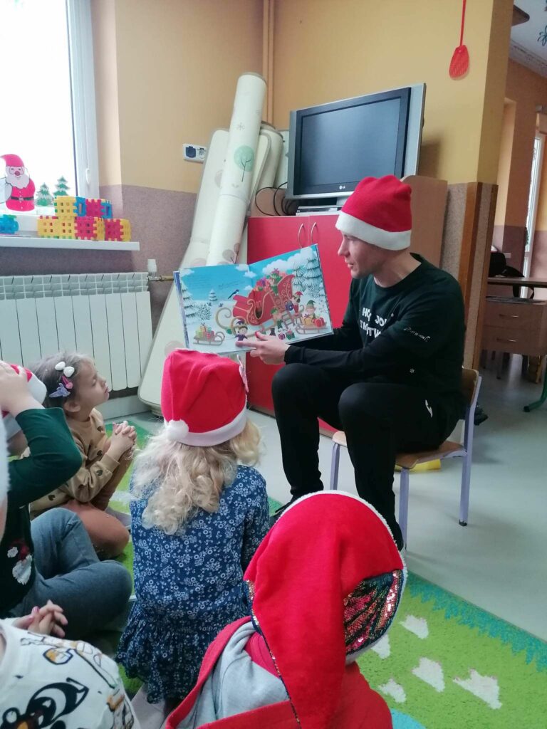 W przedszkolnej sali dzieci siedzą w kółeczku i słuchają z zainteresowaniem bajki pt. „O prawdziwym świętym Mikołaju”.