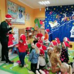 Wszystkie przedszkolaki patrzą z przejęciem i zaciekawieniem na pana bibliotekarza, który stojąc przed nimi naśladuje pewien sport zimowy, a dzieci muszą odgadnąć jaki.