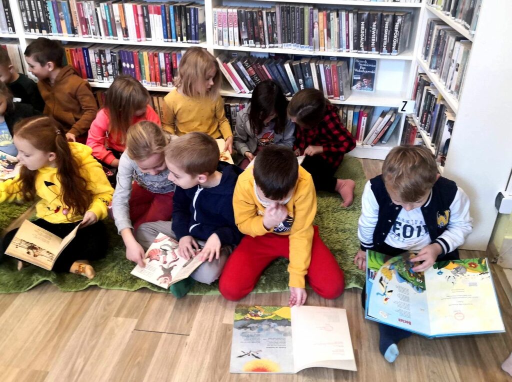na zdjęciu widać dzieci siedzące na podłodze