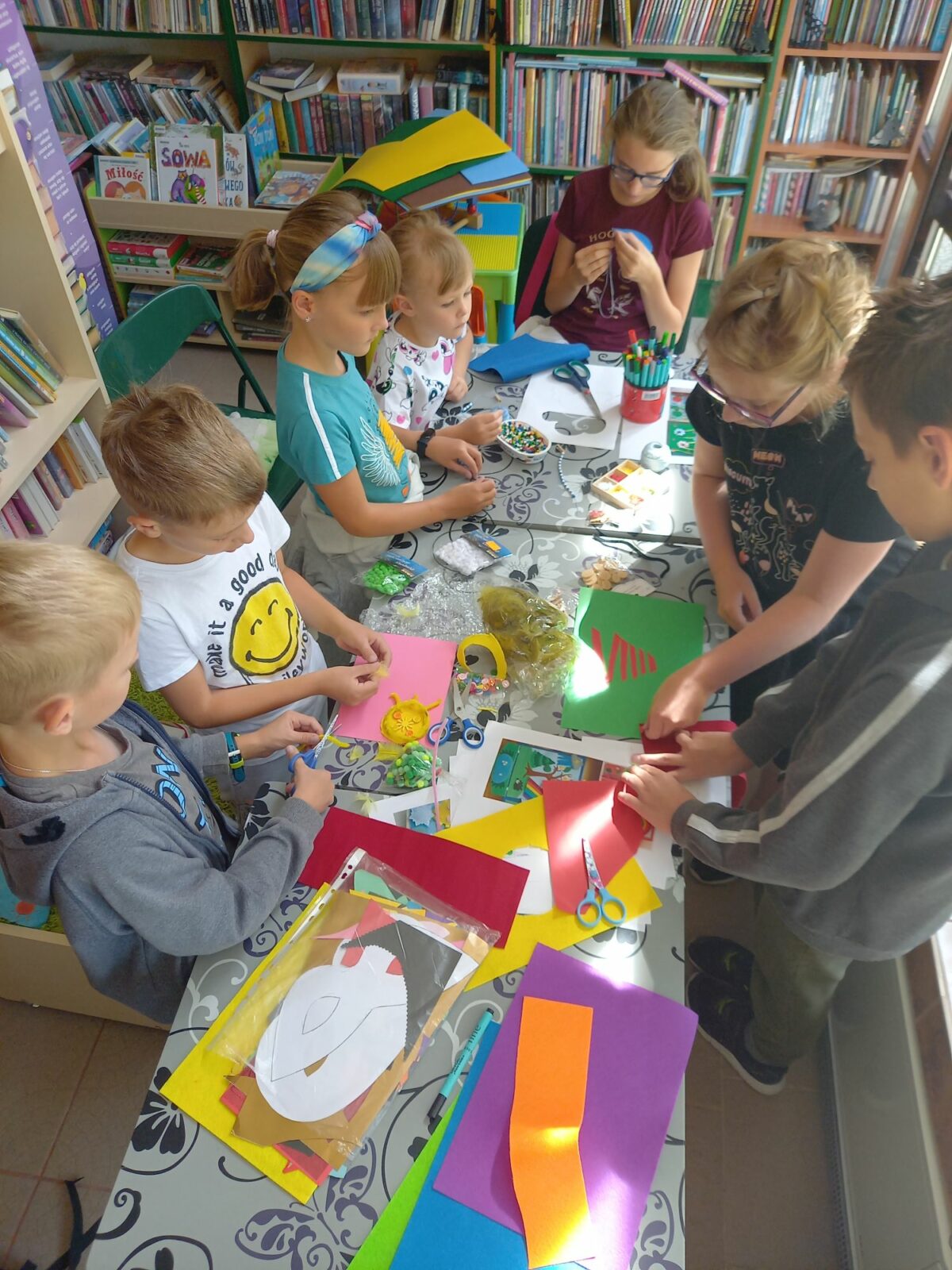 ZAJĘCIA WAKACYJNE W BIBLIOTECE NA ŹRÓDLANEJ – PRACA NAD KSIĄŻECZKĄ SENSORYCZNĄ
