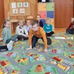 na zdjęciu widać sale przedszkolną dzieci siedzące na podłodze.