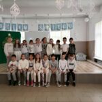 Na zdjęciu widać osiemnaście dzieci w wieku około ośmiu lat . Stoją w dwóch rzędach