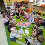 na zdjęciu widać sale przedszkolną, na dywanie siedzą dzieci