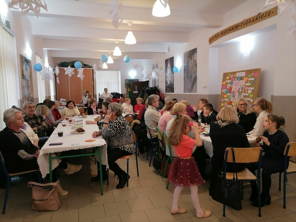 Na sali przy stołach siedzą babcie i dziadkowie. Przyglądają się występom swoich wnuków