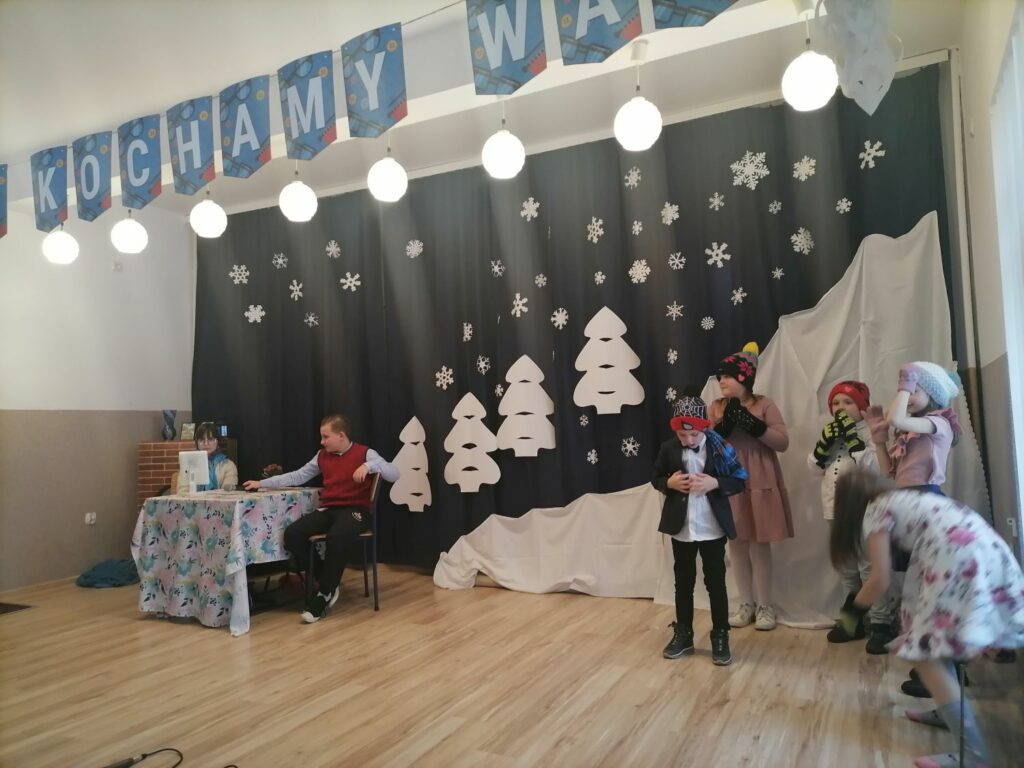 Na scenie w domu kultury w Tyliczu stoją dzieci i odgrywają przedstawienie z okazji dnia babci i dziadka