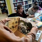 na zdjęciu widać książki o dinozaurach i dzieci