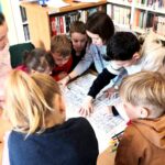 na zdjęciu widać osoby stojące wokół stołu