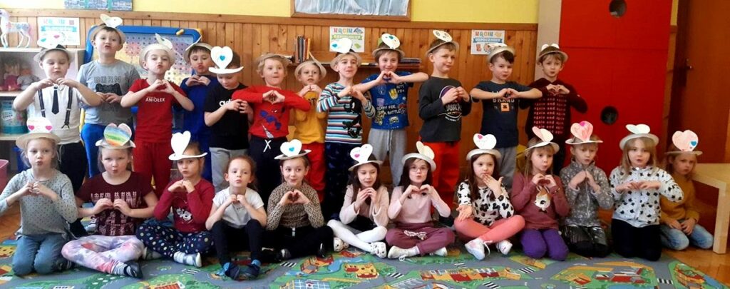 zdjęcie przedstawia grupę przedszkolaków w sali przedszkolnej.
