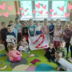 na zdjęciu widać dzieci z najmłodszej grupy przedszkolnej, prezentują zbiorową pracę plastyczną