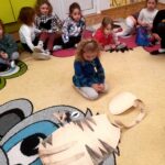 na zdjęciu widać kolorowy dywan i siedzące na nim dzieci