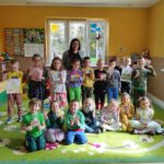 na zdjęciu widać salę przedszkolną, na środku sali stoją dzieci, prezentują wykonaną pracę plastyczną