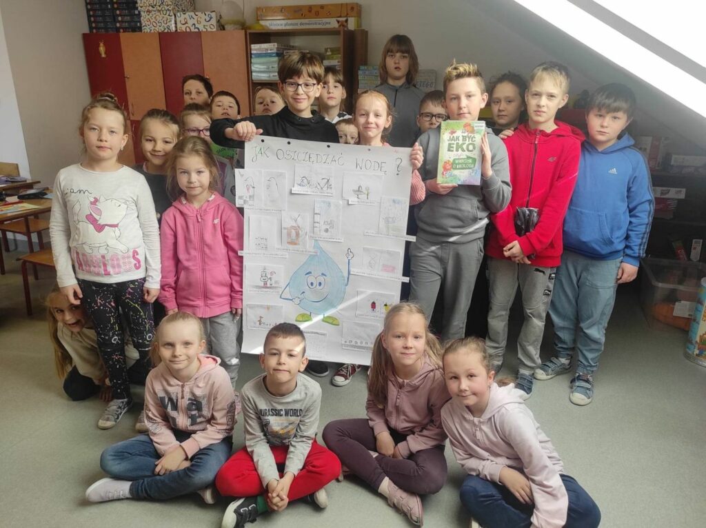na zdjęciu widać dzieci, uczniów klasy I, II i III, prezentują wykonany plakat