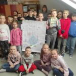 na zdjęciu widać dzieci, uczniów klasy I, II i III, prezentują wykonany plakat