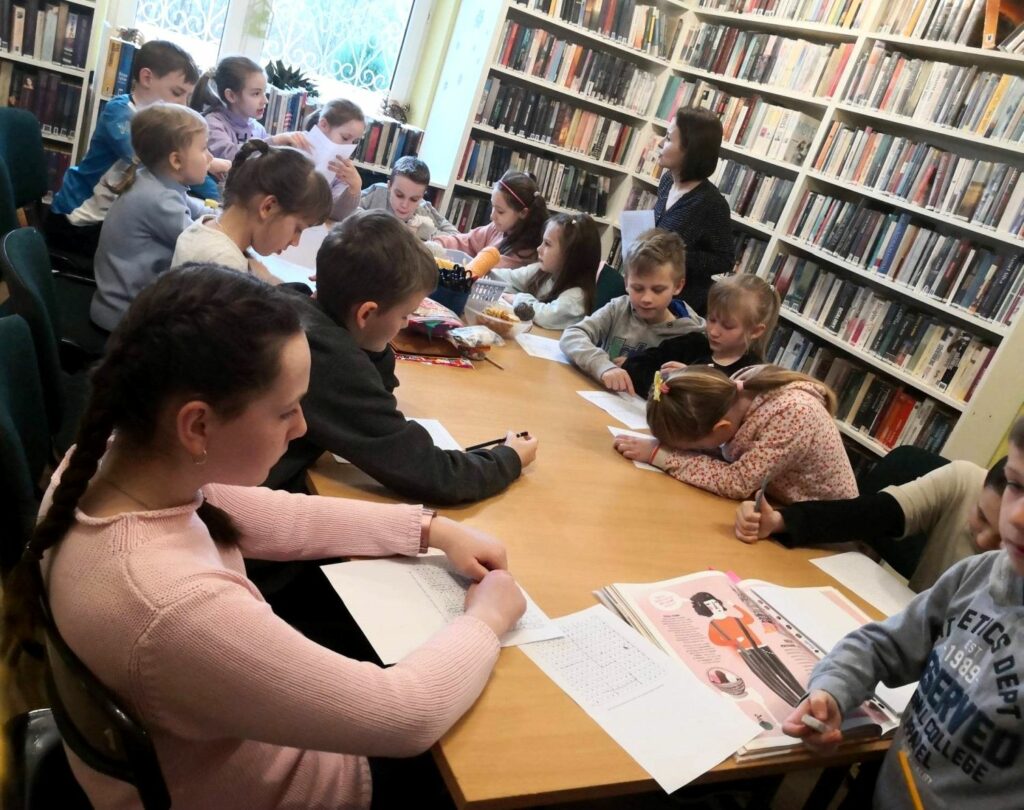 na zdjęciu widać dzieci siedzące wokół stołu