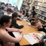 na zdjęciu widać dzieci siedzące wokół stołu