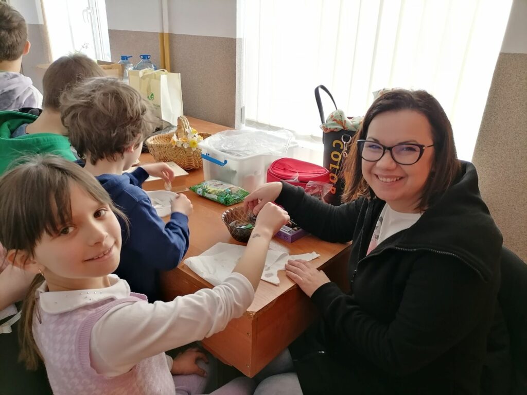 – Na zdjęciu widoczna jest pracownica biblioteki wykonująca tatuaż na ręce dziewczynki.